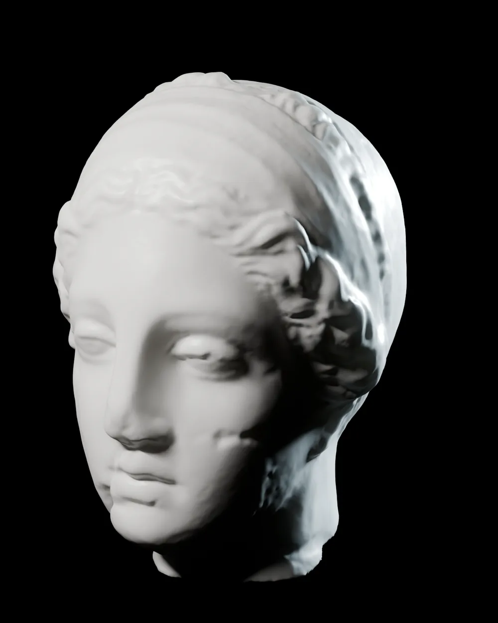 A classical white marble head in the style of Hygieia, lit from the side on black